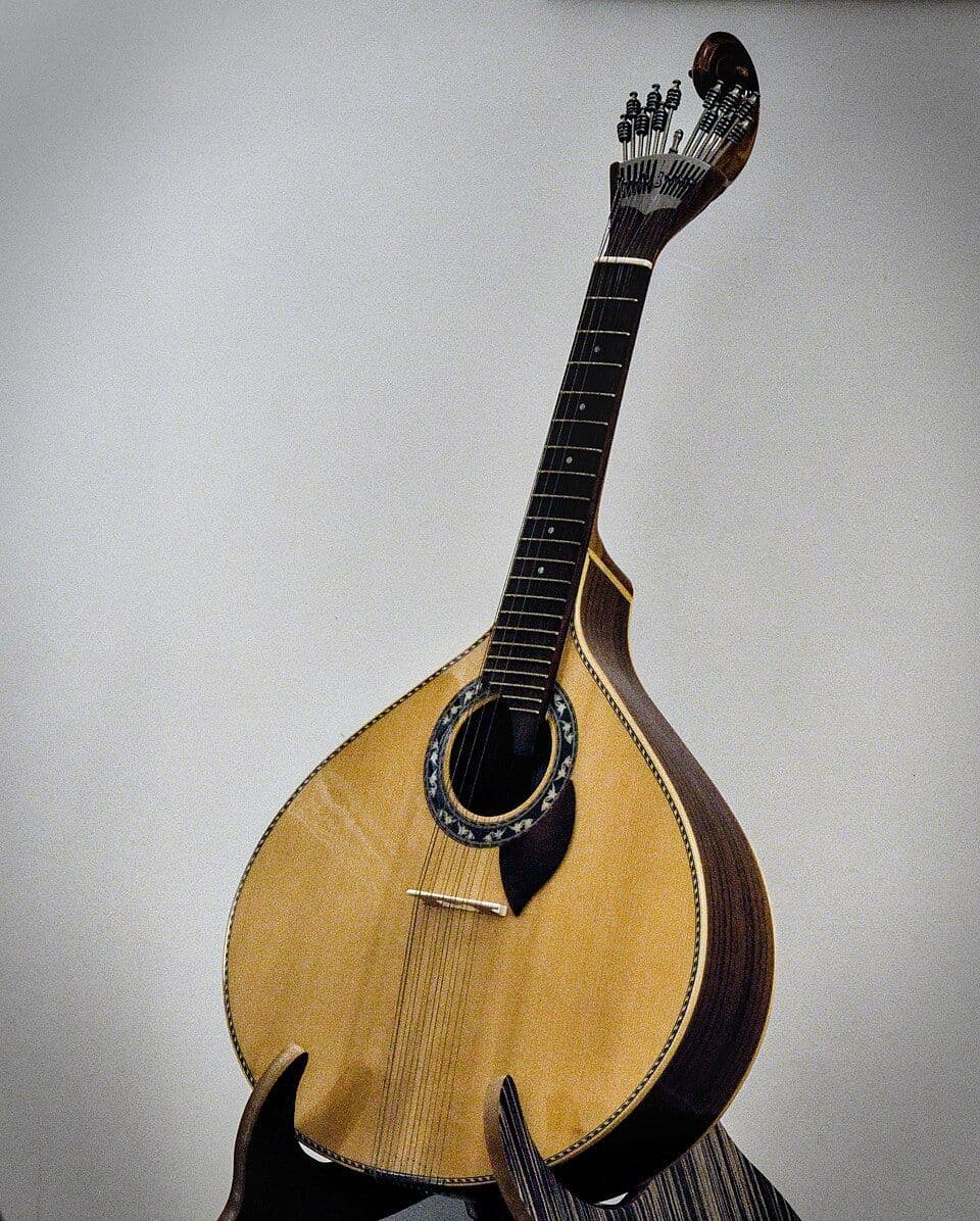 Guitarra portuguesa de caixa em forma de pera, pousada num suporte