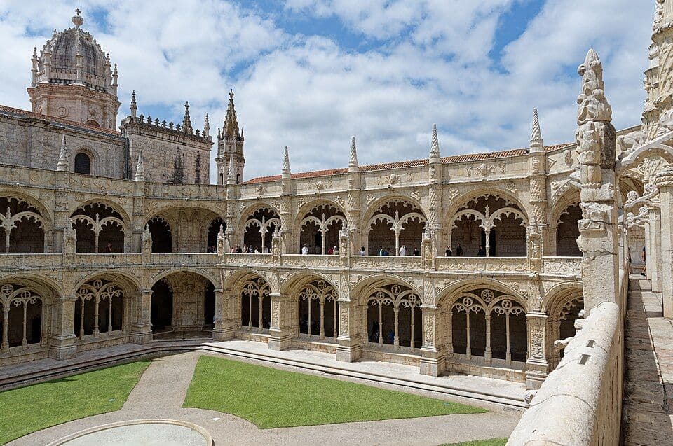 Claustro do Mosteiro dos Jerónimos, com dois pisos de arcadas em pedra lavrada e relvado ao centro