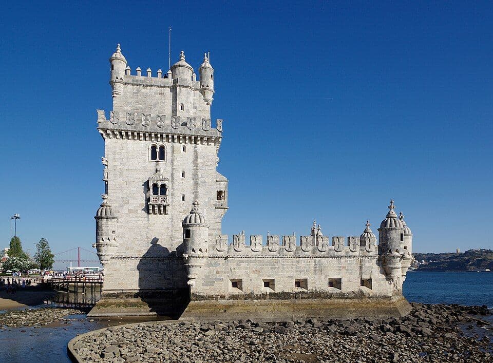Torre de Belém, em pedra clara, à beira do Tejo e sob céu azul