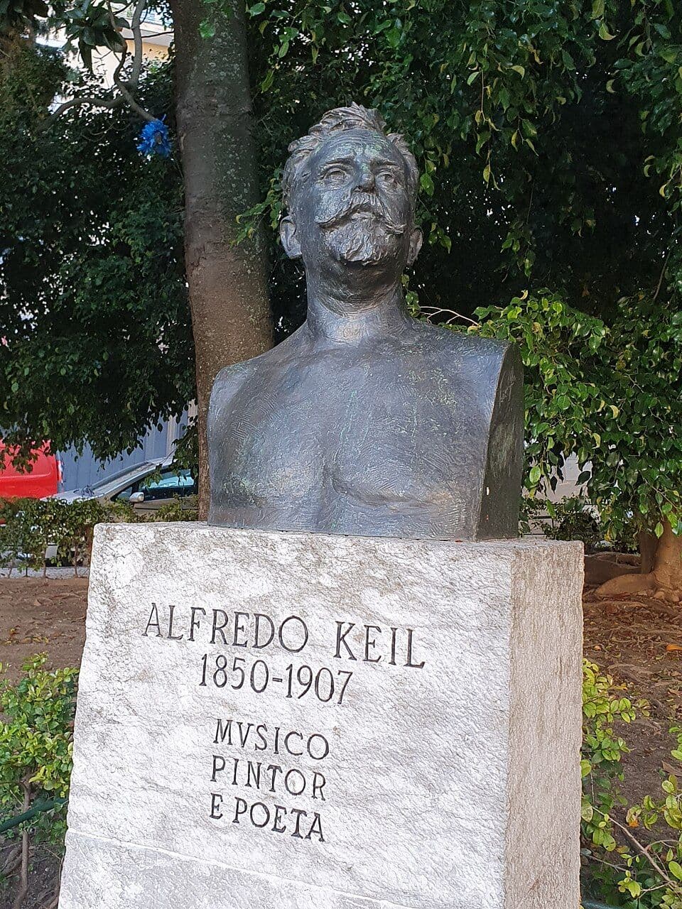 Busto de bronze de Alfredo Keil sobre um pedestal com a inscrição Alfredo Keil 1850-1907, músico, pintor e poeta